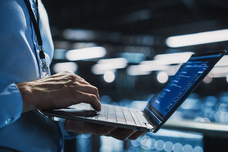 Provide valuable managed IT services to your customers with Insight. Data center technician working off laptop in modern data center. Managed service provider support. IT service provide