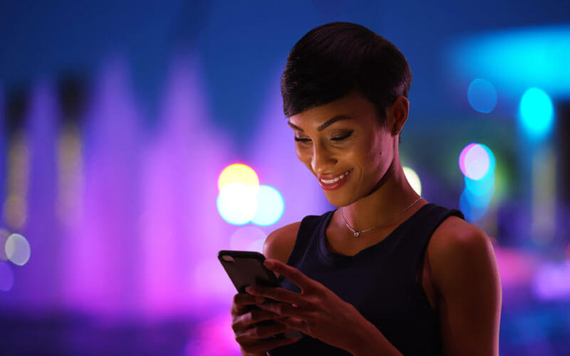 Woman working on technology device at night outside