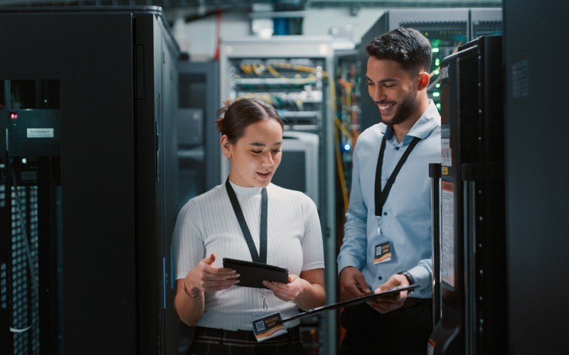 it_experts_between_servers_800x500 man and woman discussing in a server room