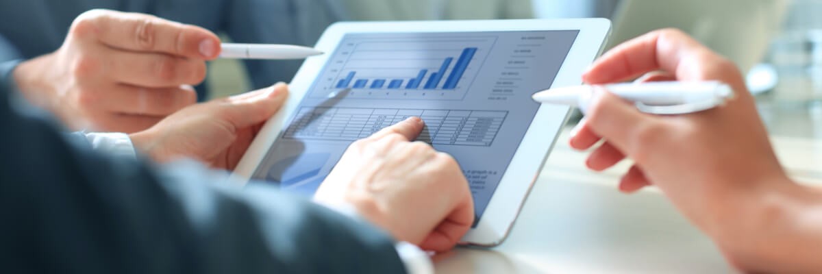 The Best SQL Server Business Intelligence Three people using a tablet to compare statistics and look at information.