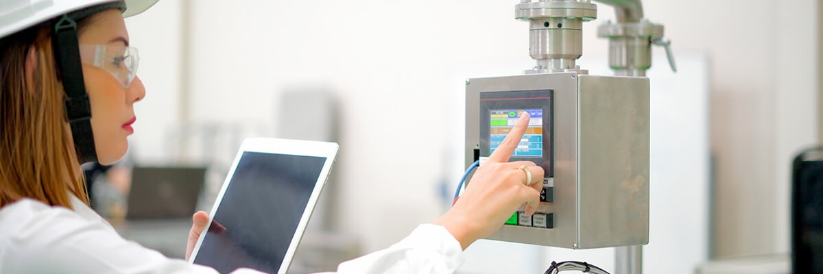 The Industrial IoT: Why Building Your Smart Factory Can’t Wait Manufacturing worker uses a tablet to control a machine.