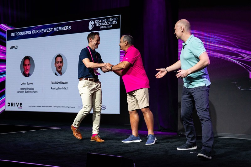 The Distinguished Technologist program guides our company's strategy and enhances our offerings. John Jones shakes hand with Juan Orlandini and Phil Hawkshaw at Insight Mastery event 2024