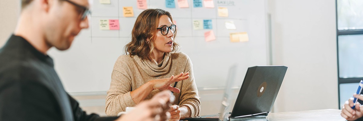 Becoming a Leader That Crushes Technical Debt Team discussing in open office