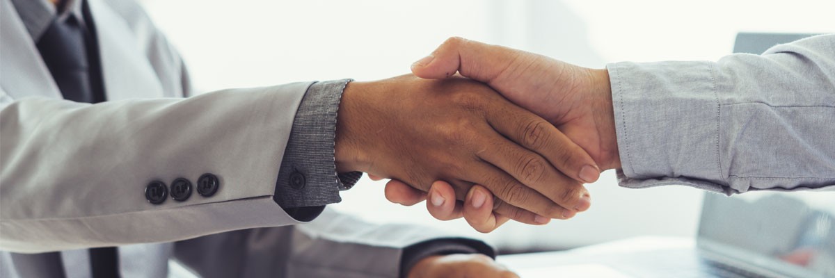 Follow these tips to make your next career fair visit a success Recruiter shaking hands with prospective employee at career fair
