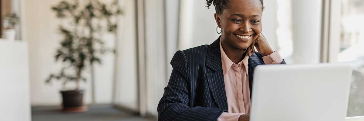 Google Sheets vs. Excel Girl smiling at laptop