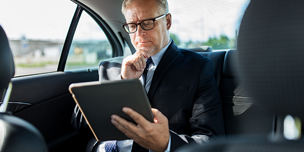 Gain a comprehensive overview of the full range of available Cisco IT solutions business man using tablet in moving vehicle