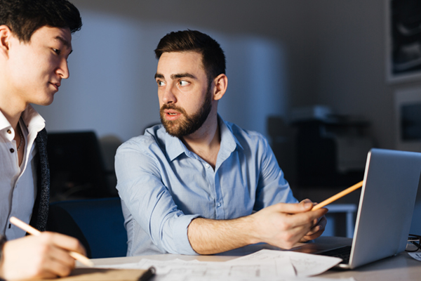 Choosing the right approach for your business Two IT professionals creating networking strategy in office at night