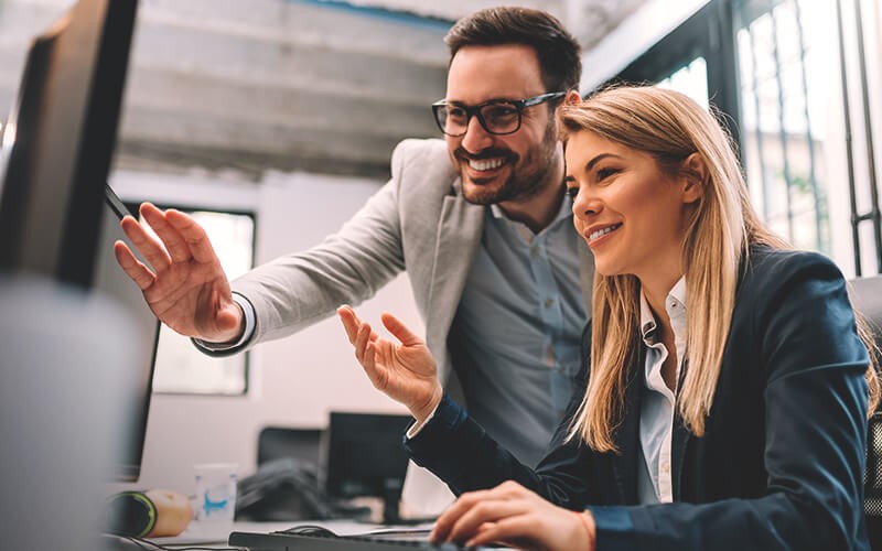 Meet unique demands for advanced analytics Two professionals working together on workstation computer