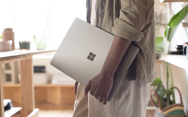 Help your retail business enhance customer engagement Man in small retail business holding Surface device in hand