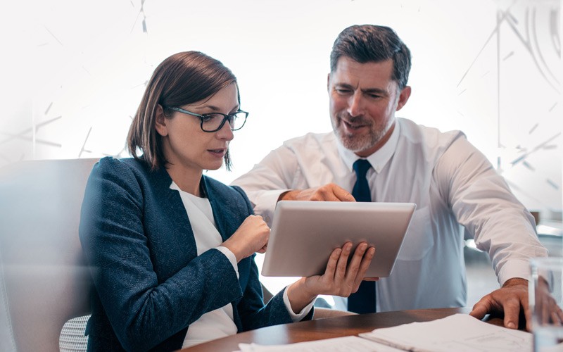 Planning a risk management strategy Business professional reading whitepaper off of tablet computer