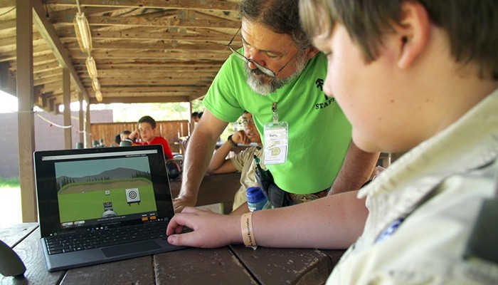 Provide strong, wireless network connections to large areas Camp instructor helping Boy Scout with hunting game on notebook computer