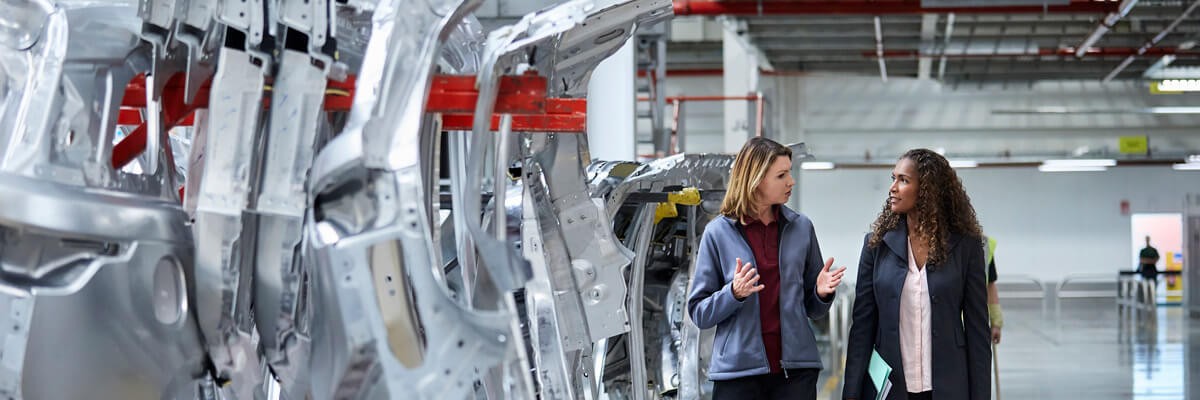 Procure, maintain and replace the technology to run your business Technicians walk through a large manufacturing facility