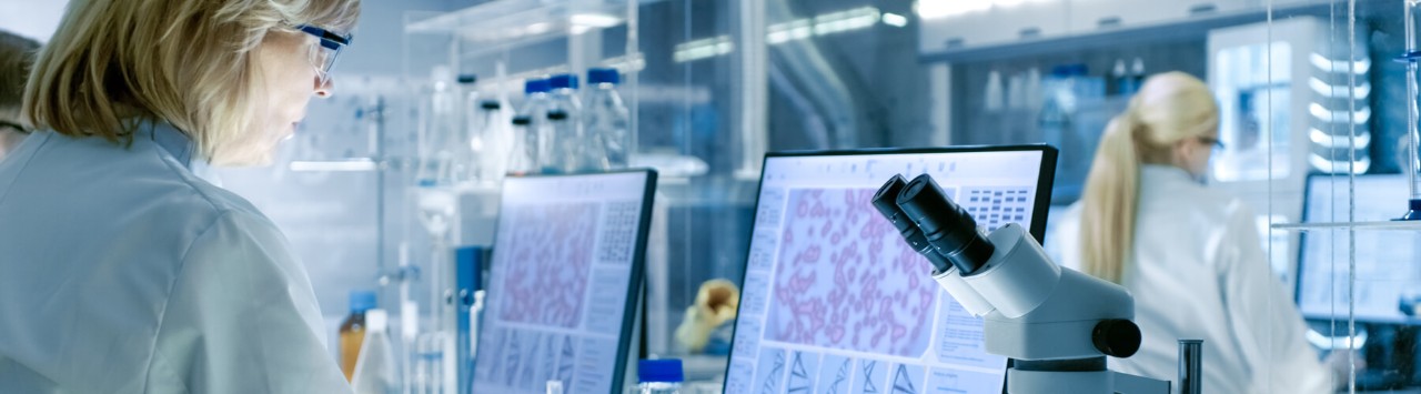 Simplify the process of procuring, maintaining and replacing the technology Health technician looking at patients cells magnified on desktop monitor