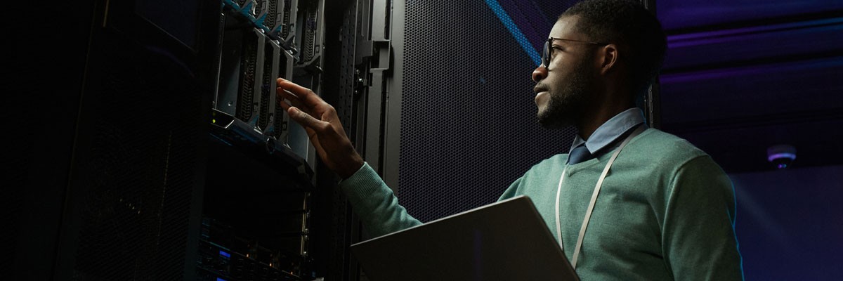 IT Organization at Large Enterprise Creates Vulnerability Management Program Businessman on laptop device in server room