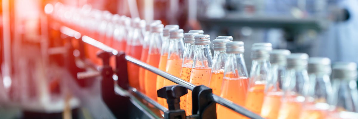 Large Beverage Bottler and Distributor Looks to Address Wide-Ranging IT Challenges in Preparation for Tripling in Size Close up view of bottles on a conveyor belt
