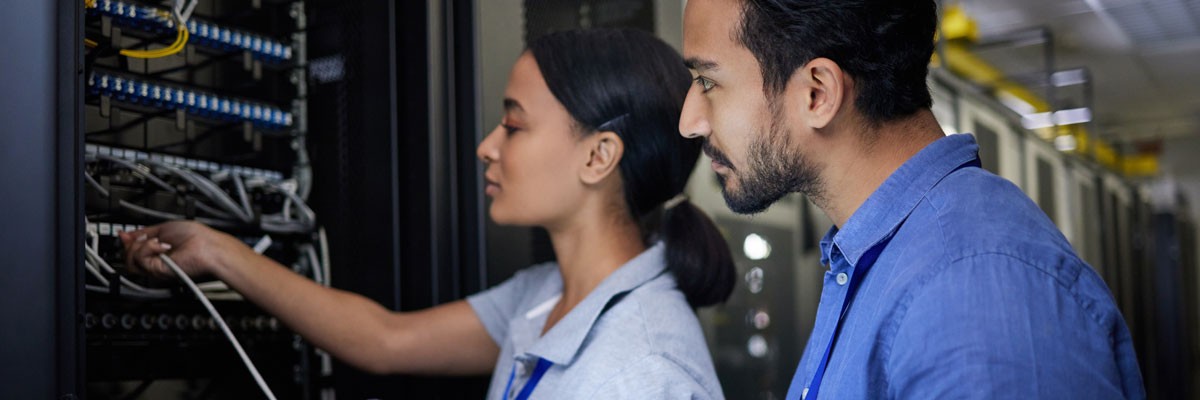 Networking Technology Company Protects Data Easily and Cost-Effectively With Rubrik Solution Two IT professionals working in network and server room