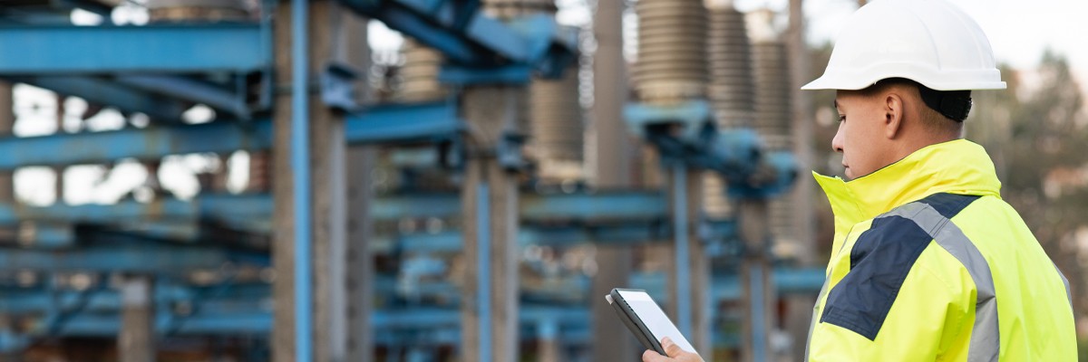 Utilities Company Increases Customer Satisfaction and Reduces Project Costs Through Agile Adoption Utilities worker uses tablet device while on-site