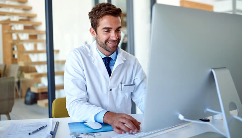 Best Practices for Securing Patient Data webinar Doctor looking at patient data on desktop computer