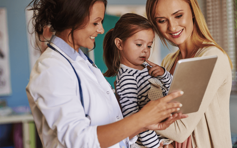 Cloud opportunities for the healthcare industry Doctor with child patient and mother showing tablet device
