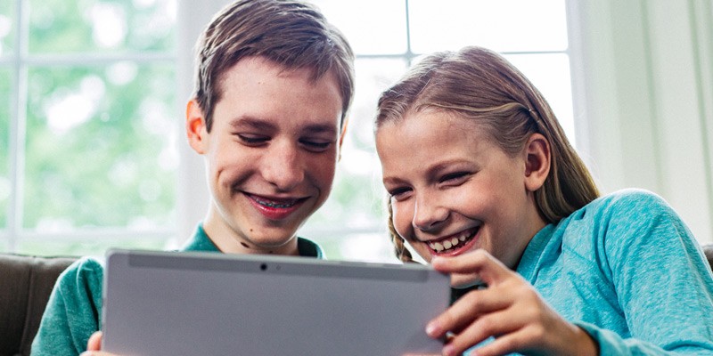 Steps to define and carry out K-12 digital vision. K-12 teacher helping students in a classroom.