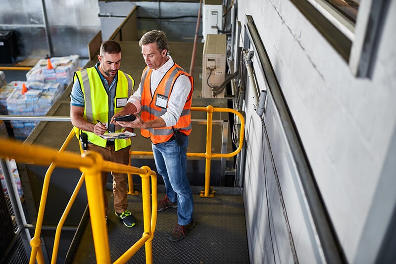 The most common challenges facing growing businesses Two men on tablet device in manufacturing facility