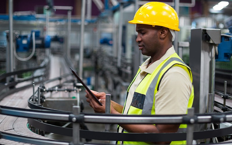 Review several benefits of SD-WAN for manufacturing companies. Manufacturer reviewing info securely over SD-WAN network.