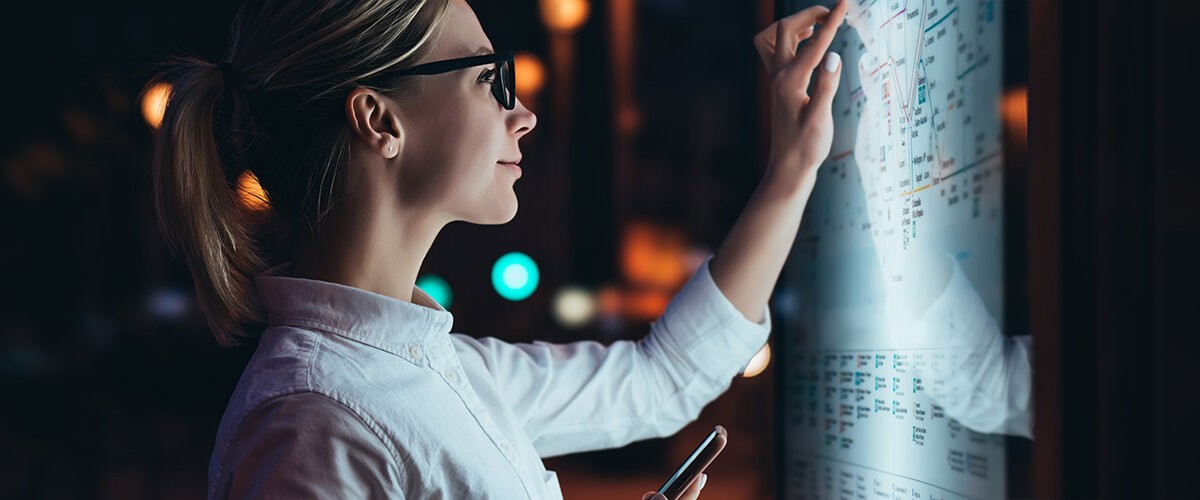 Data is the lifeblood of society today Woman checks bus route on digital touch display in modern city.