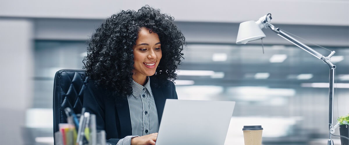 Every business challenge is unique, but the answer is out there. Business woman at desk using laptop computer. Artificial intelligence, computer vision