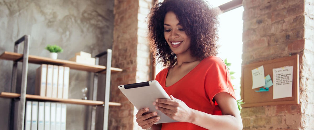 Discover how enterprises are shifting their strategies to ensure a productive, happy and connected workforce. Business professional reading data off tablet computer. IT lifecycle management. IT lifecycle deployments. IT lifecycle