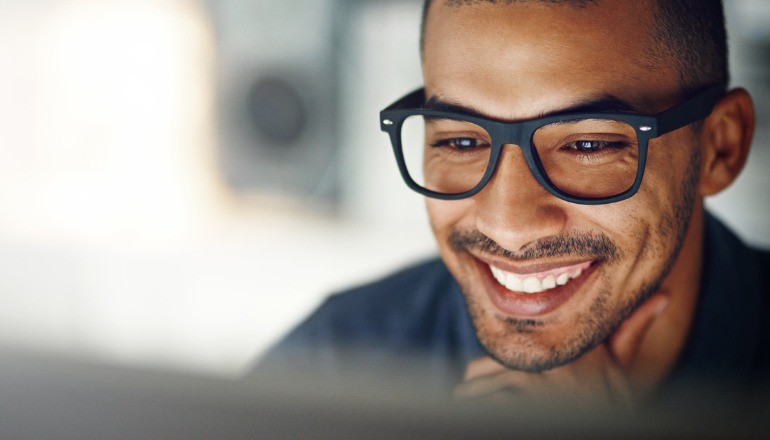 Get More Value From Your Microsoft Solution With Adobe Man smiling at desktop