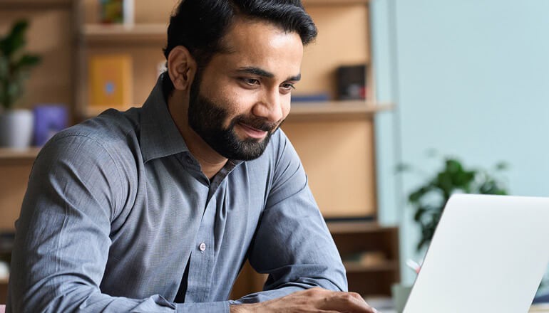 Simplify deployment and management across your entire device fleet Man using laptop for work at home. Windows 11, Device deployment, device manageability, deployment and manageability