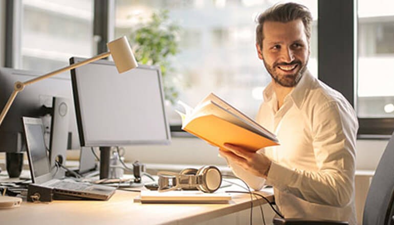 Learn how Check Point solutions provide protection across your IT ecosystem. IT professional smiling while reviewing documents at computer. Check Point security solutions
