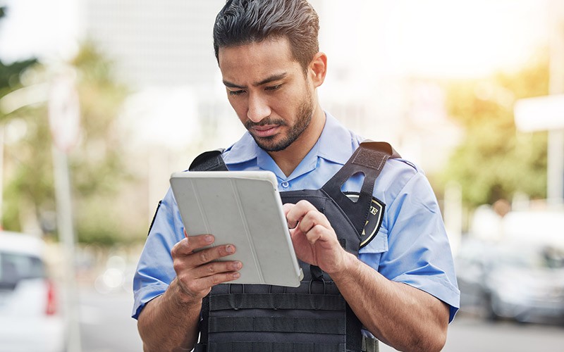 police-officer-in-field-tablet-device-tech Police officer on tablet device in field