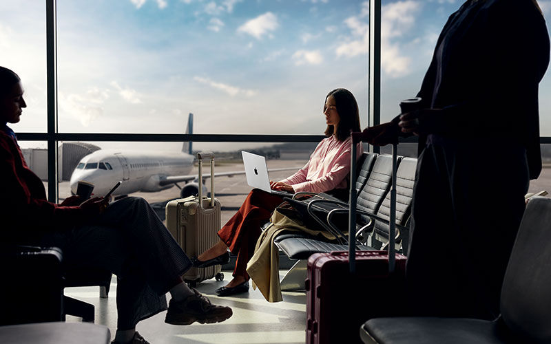 Elevate your device management approach. Woman working on laptop at coffee shop