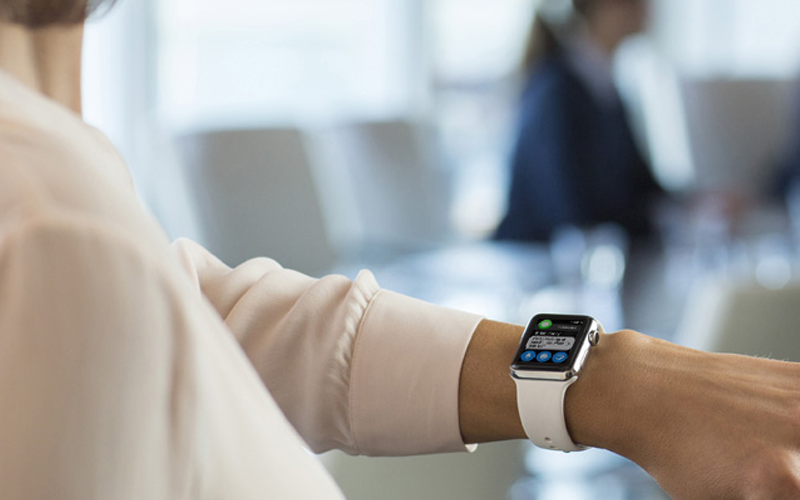 Apple Watch can incorporate your applications and deliver them to all of your workers Woman in meeting room holding wrist up to look at her Apple Watch