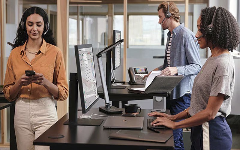 Directly support customer needs with ease View of workers with headsets working at Cisco Contact Center