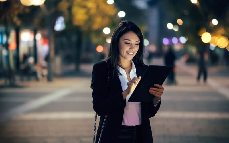 Citrix Virtual Apps and Desktops Business woman in street at night using tablet