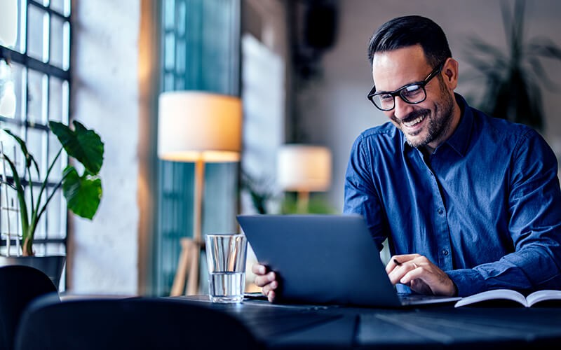 Cloud solutions Man smiling using his tablet at the cafe