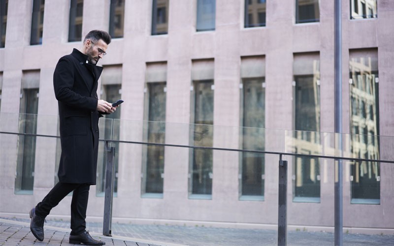 IT services for federal government Business man walking outside using cell phone