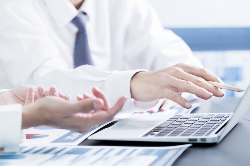 Enhanced File Transfer Enterprise Closeup of two sets of business men's hands working on laptop.
