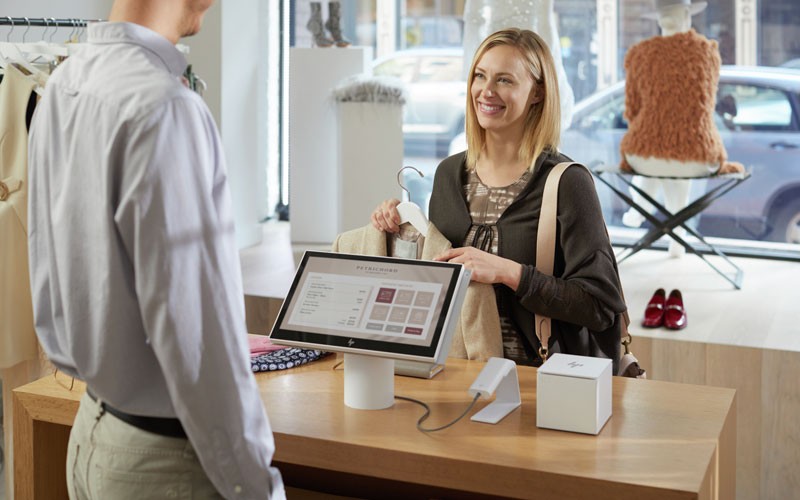 HP ElitePOS Retail System series HP lifestyle shopper purchasing at check out with HP ElitePOS product