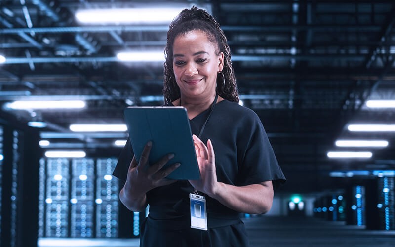 Turn complexity into clarity. Woman standing holding her tablet