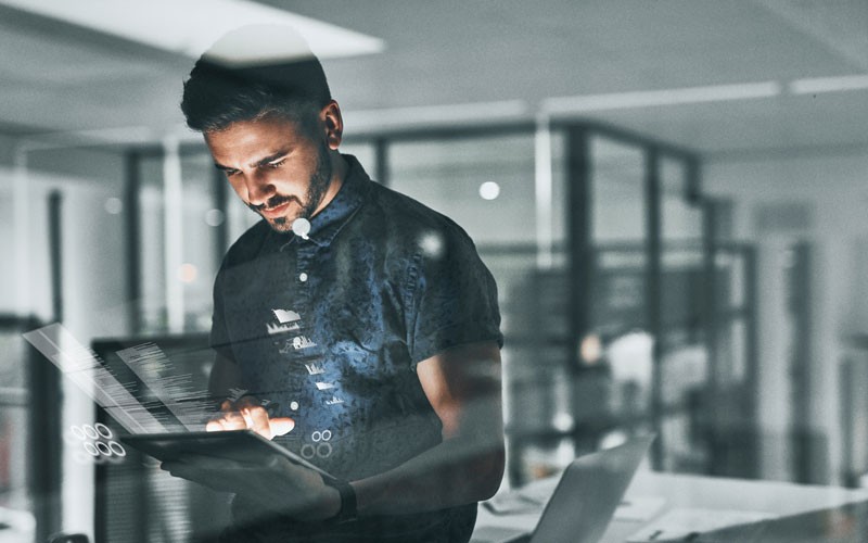 man-working-on-tablet-device-with-graphic-overlay man-working-on-tablet-device-with-graphic-overlay