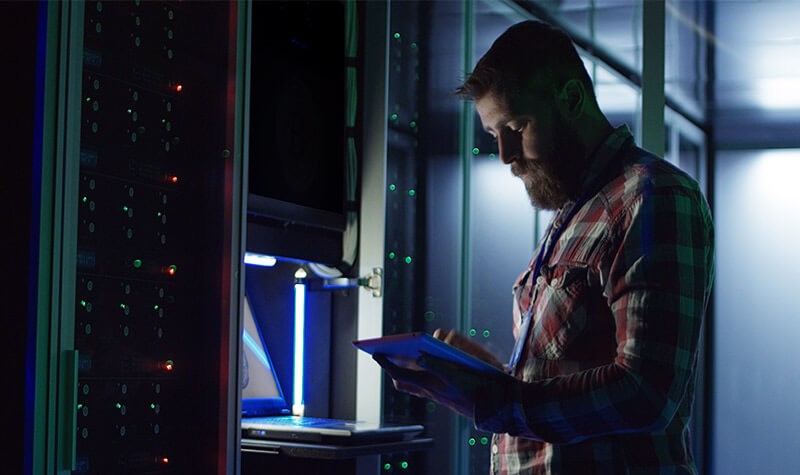 Enterprise-level cloud services IT admin reviewing data center information on tablet computer