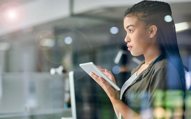 woman-working-on-tablet-looking-up woman-working-on-tablet-looking-up