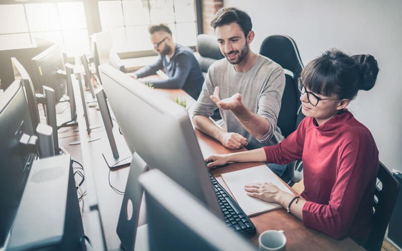 Educate employees on common security threats Coworkers collaborating at laptop device