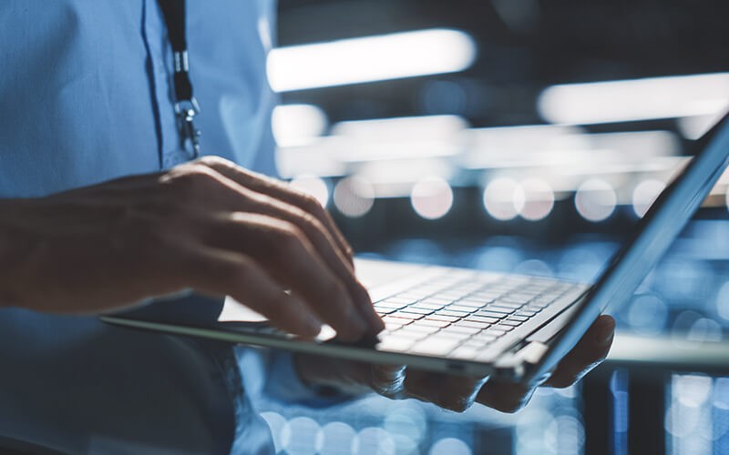 Solve issues before they become a major incident. Person using a laptop at work