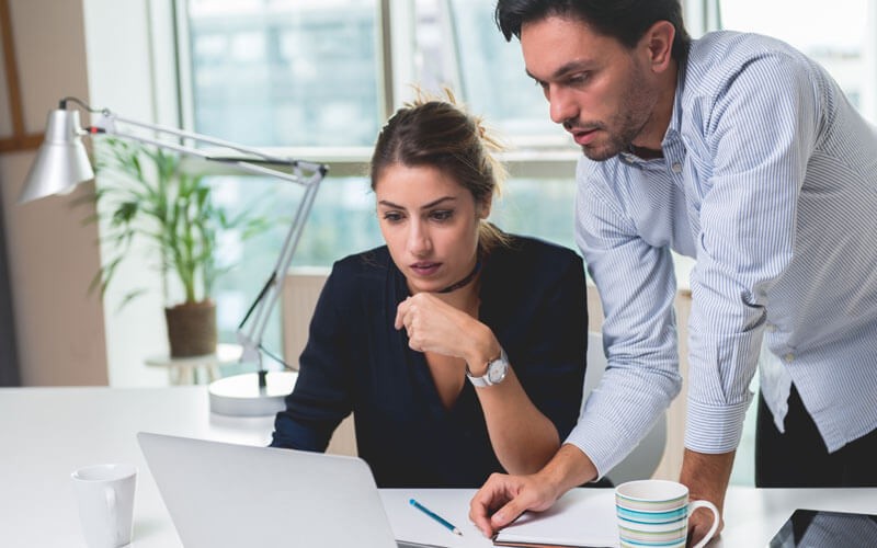 Unified data backup Two people looking over laptop screen