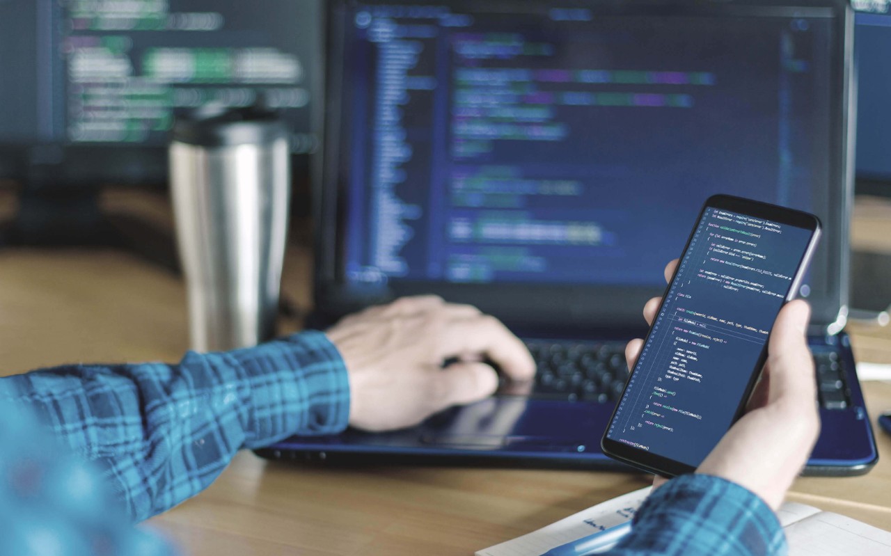 NetBackup SaaS protection Man using his smartphone at work