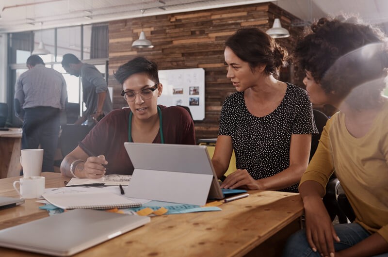 Insight has over 150 certifications related to Veritas products. Business team talking around modern community desk seating